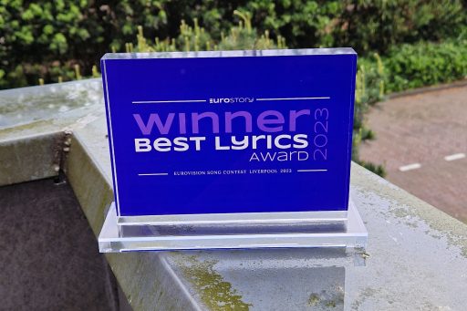 A picture of the Eurostory Best Lyrics Award 2023: a rectangular trophy of purple glass. On it, the text reads: "WINNER – Best Lyrics Award 2023"